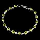 A 925 silver bracelet set with round cut peridots and black spinels, L. 18cm.