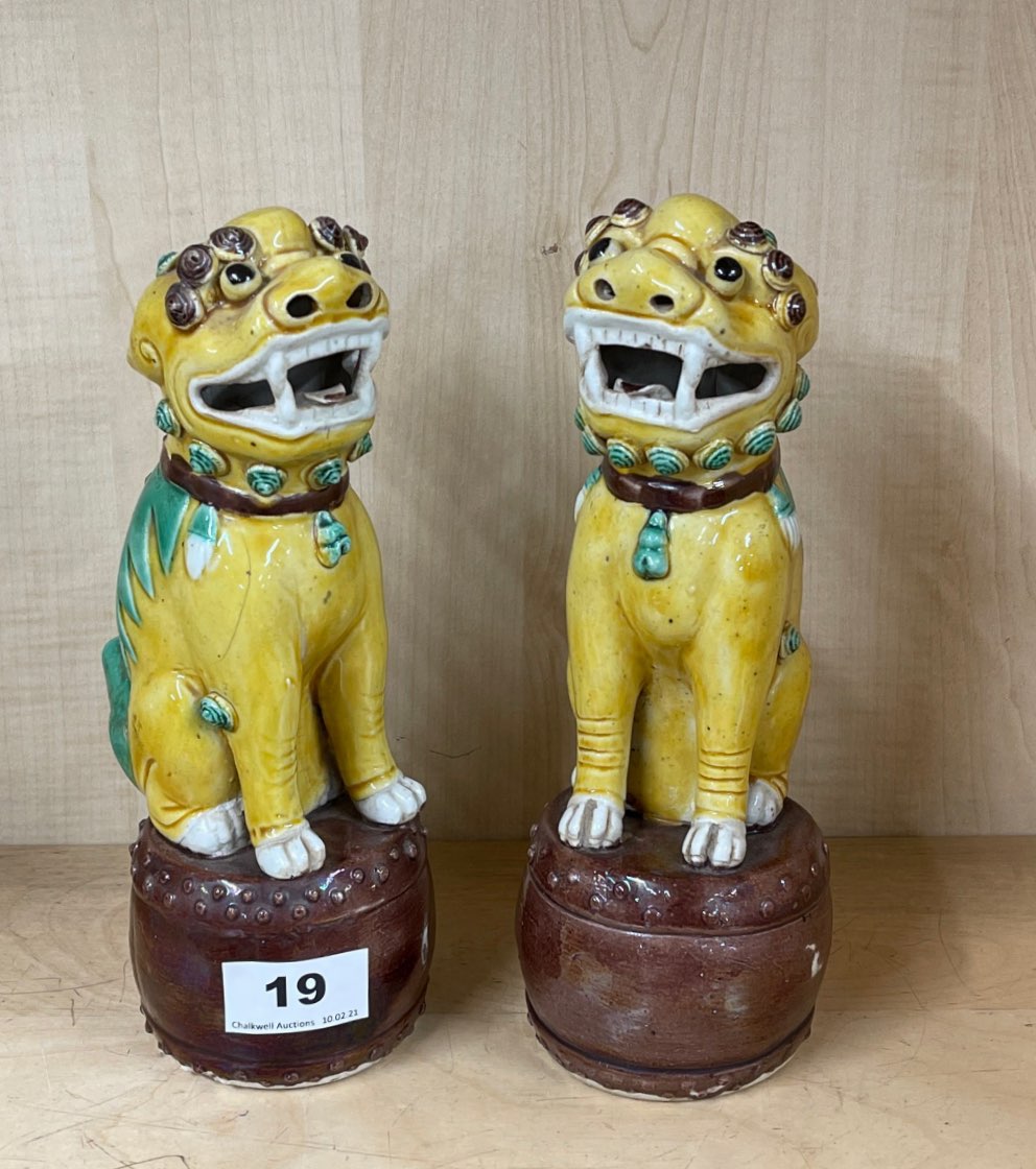 A pair of Chinese glazed porcelain lion dog figures standing on drums, H. 23cm. Condition: one A/F.