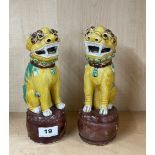 A pair of Chinese glazed porcelain lion dog figures standing on drums, H. 23cm. Condition: one A/F.