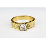 An 18ct yellow gold (stamped 18ct) ring set with a brilliant cut centre diamond and brilliant cut