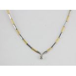 An 18ct yellow and white gold necklace set with a brilliant cut diamond, approx. 0.30ct, L. 40cm.