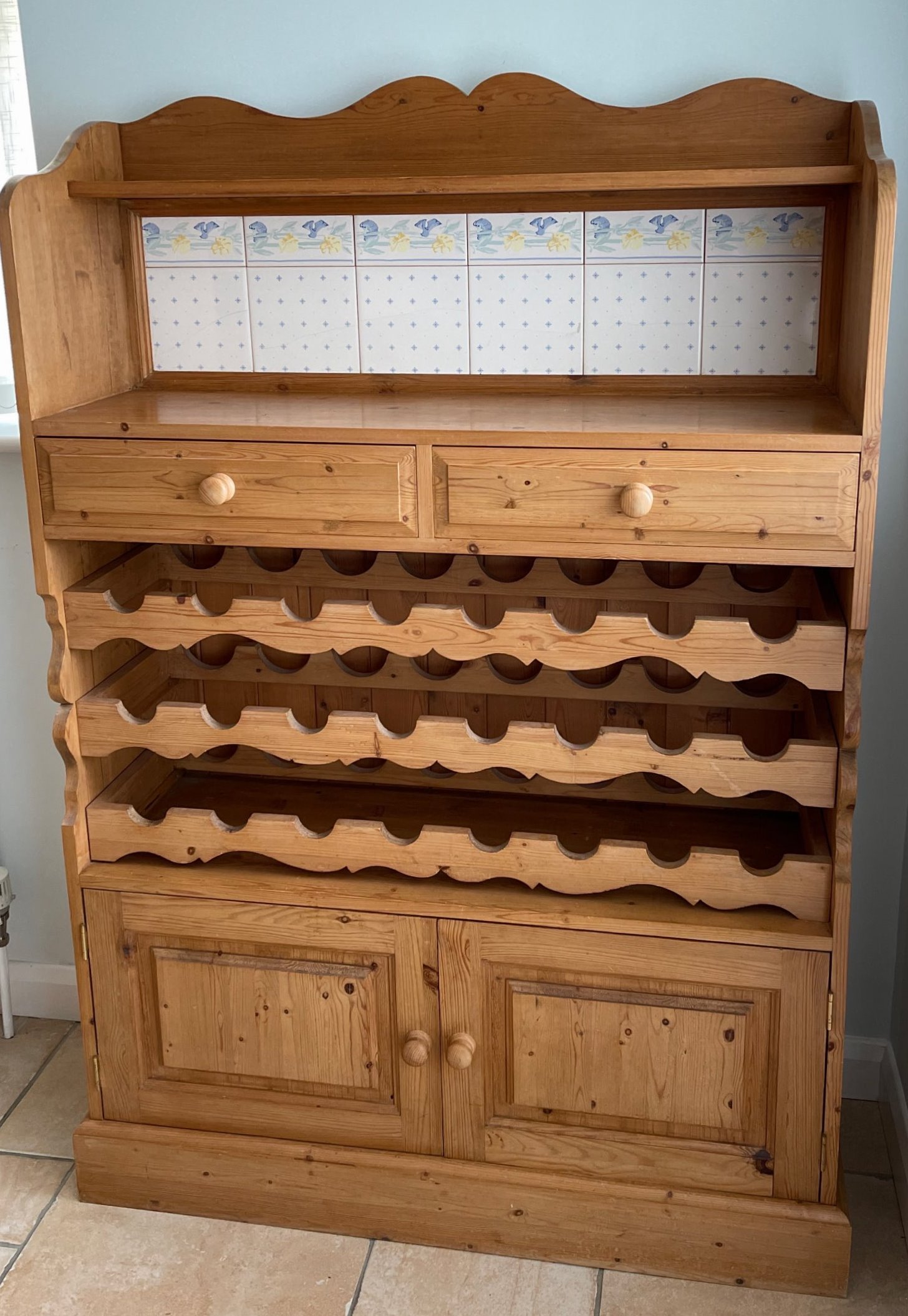 A pine tile inset kitchen cabinet with an in-built wine rack, 100 x 150cm. Condition: some tiles A/