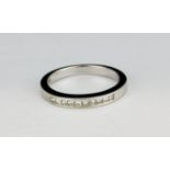 A 14ct white gold (stamped 14k) half eternity ring set with princess cut diamonds, (L).
