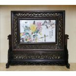 A Chinese carved hardwood and hand painted porcelain table screen, H. 37cm, W. 39cm.