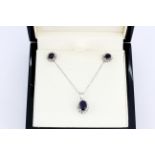 A suite of matching 9ct white gold pendant and chain and matching pair of earrings, set with oval
