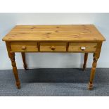 Three drawer pine side table, W. 107cm.