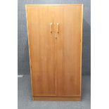 A 1970's G-plan elm double wardrobe, H. 175cm. W. 91.5cm.