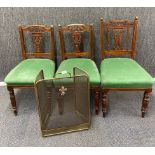 Three carved Edwardian hall chairs together with a brass fireguard.