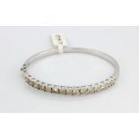 A 9ct white gold bangle set with brilliant cut diamonds, approx. 3ct.