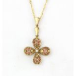 A 9ct yellow gold flower shaped pendant set with diamonds and orange sapphires, L. 4cm.