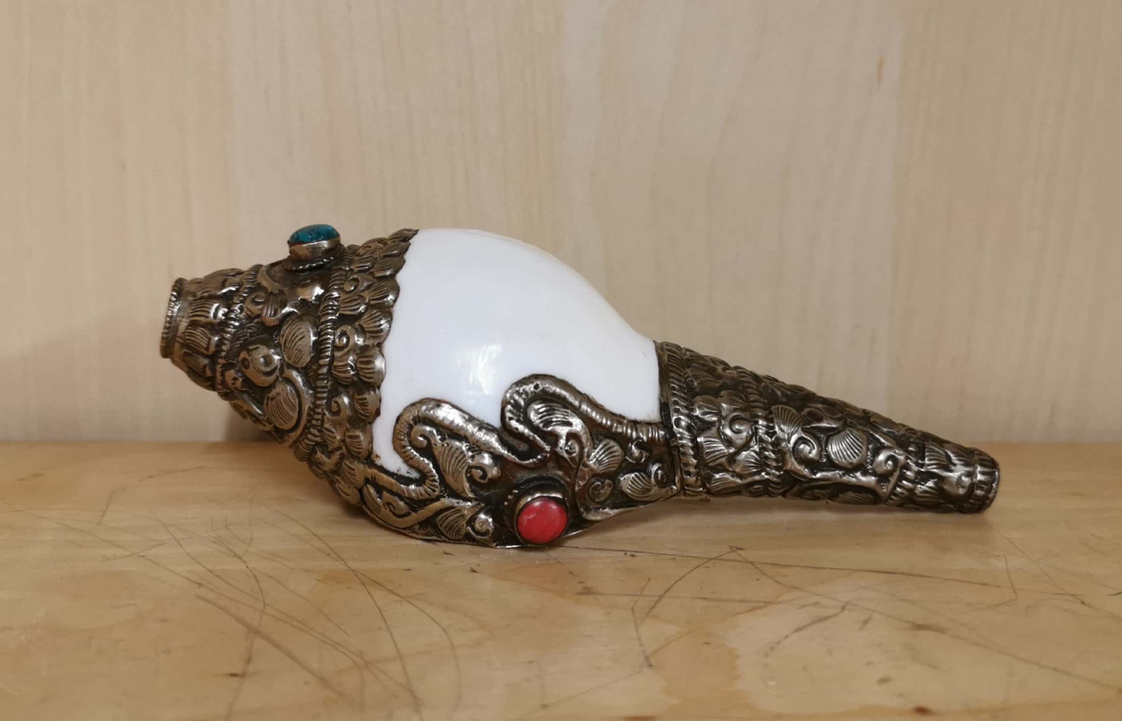 A Tibetan white metal decorated conch shell trumpet, L. 15cm.