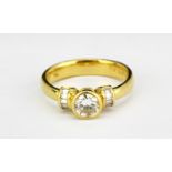 An 18ct yellow gold rings set with a brilliant cut diamond and baguette cut diamond shoulders,