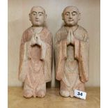 A pair of Chinese carved wood and painted figures of monks, H. 30cm.
