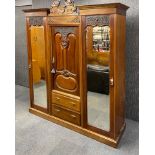 A Victorian carved mahogany triple wardrobe, H. 211cm.