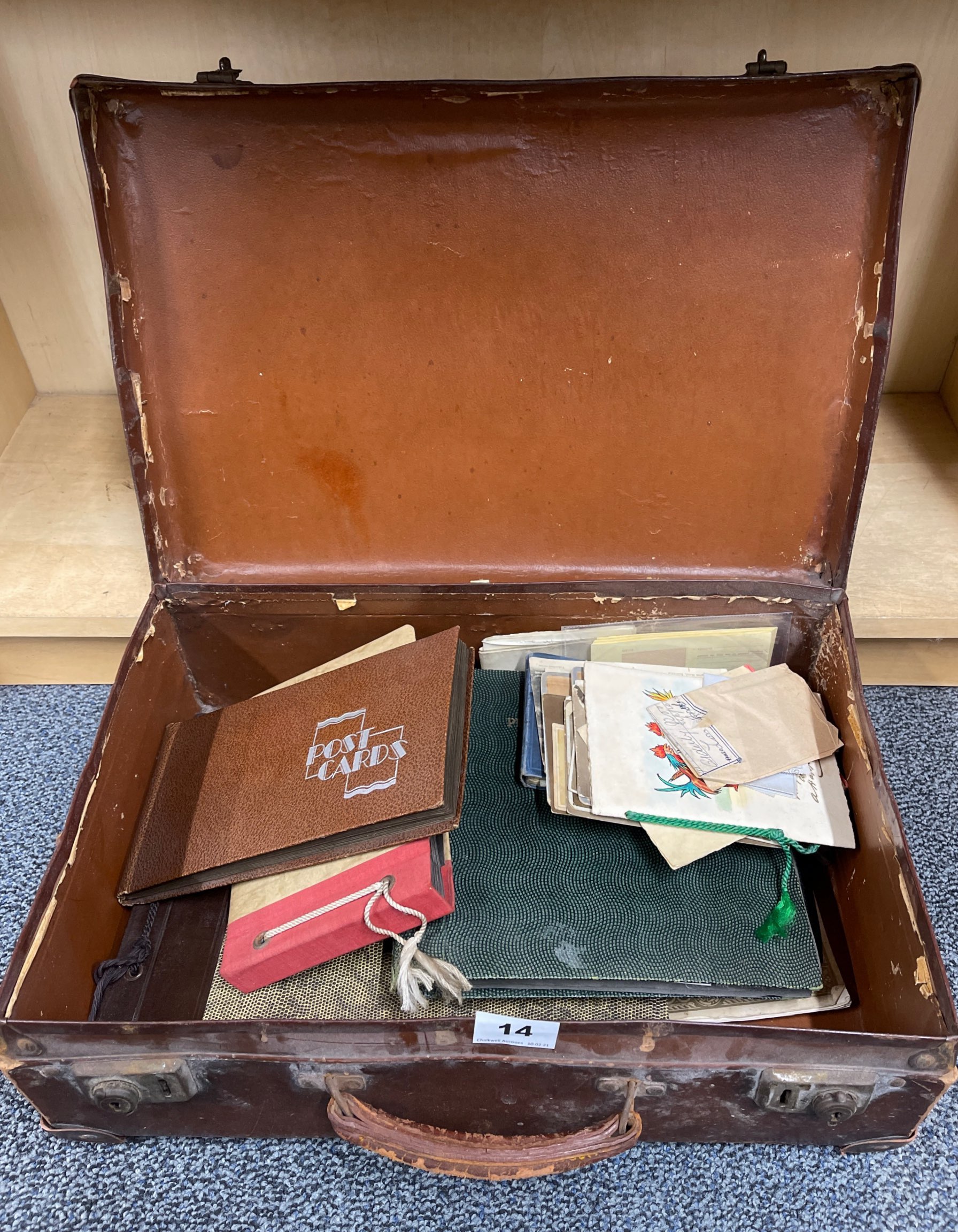 A small vintage suitcase of photograph albums and other items.