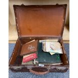 A small vintage suitcase of photograph albums and other items.