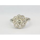 A white metal (tested high carat gold) diamond set cluster ring, approx. 1.30ct overall, (L.5).