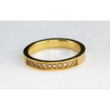 A yellow metal (tested 9ct gold) diamond set half eternity ring, (N).