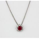 An 18ct white gold (stamped 750) necklace set with a round cut ruby surrounded by brilliant cut
