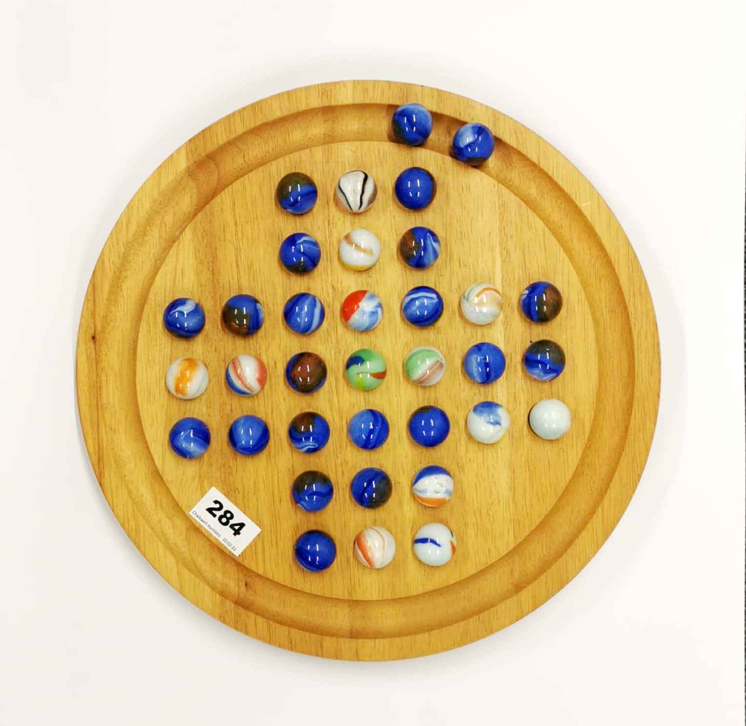 A wood and large glass marble solitaire game, dia. 34cm, marble dia. 2.5cm.