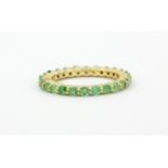 A 925 silver gilt emerald set full eternity ring, (N).