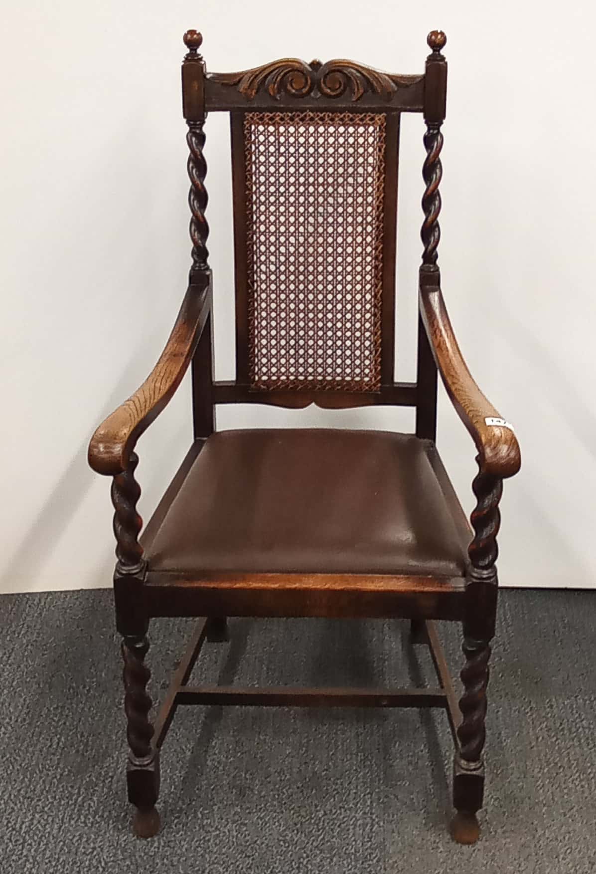 A cane backed barley twist decorated oak hall chair.