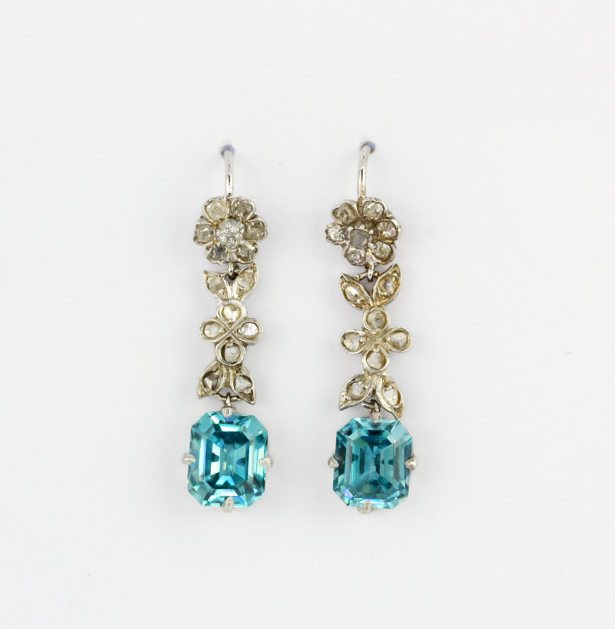 A pair of white metal (tested high carat gold) drop earrings set with emerald cut natural blue