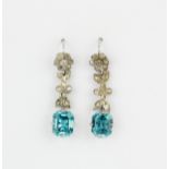 A pair of white metal (tested high carat gold) drop earrings set with emerald cut natural blue