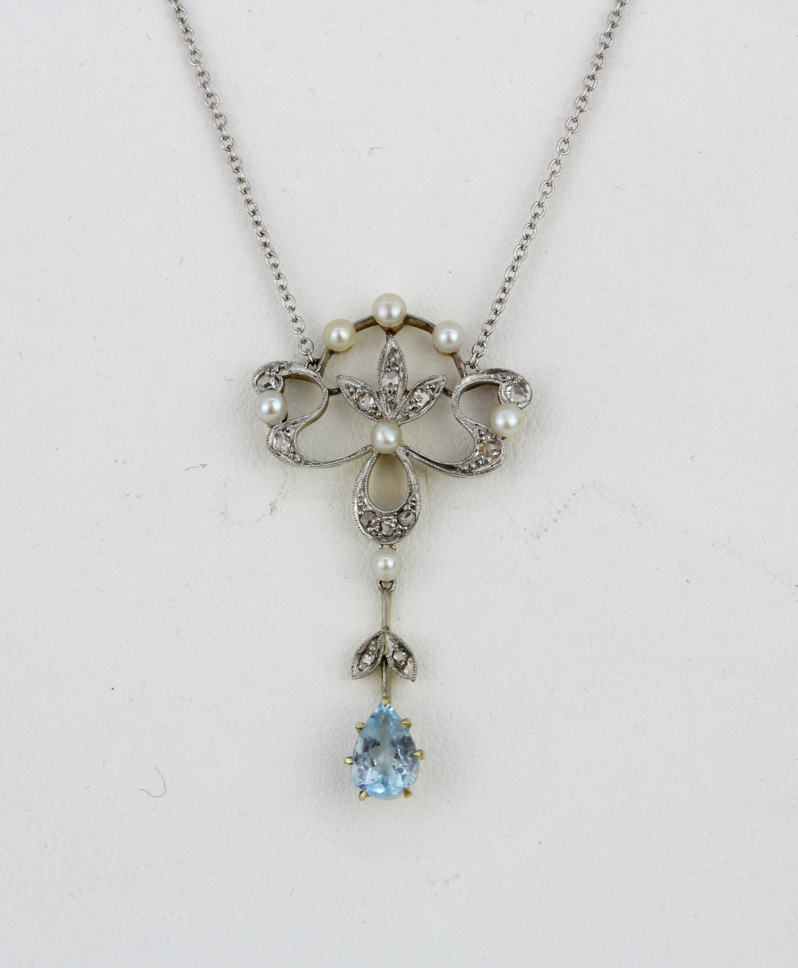 An Art Nouveau yellow and white metal (tested gold and silver) necklace set with pear cut blue