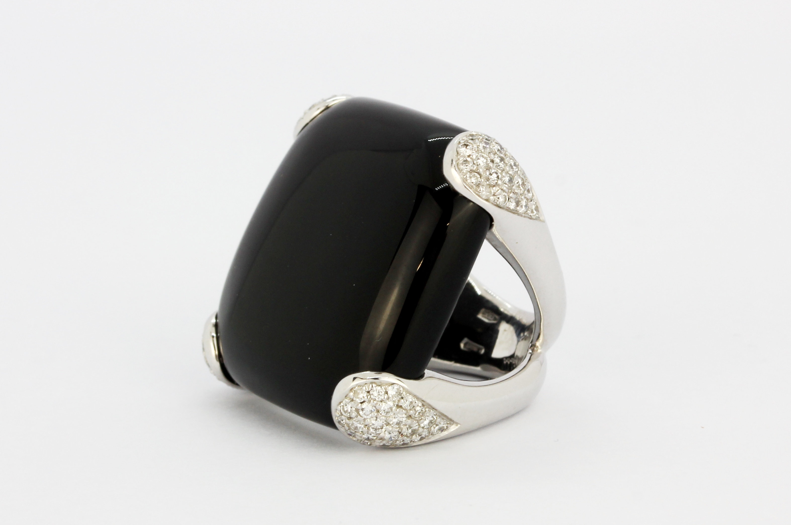 An 18ct white gold ring set with onyx and diamonds, L. 2.5cm, (K).