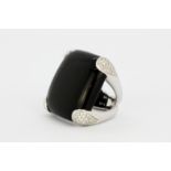 An 18ct white gold ring set with onyx and diamonds, L. 2.5cm, (K).