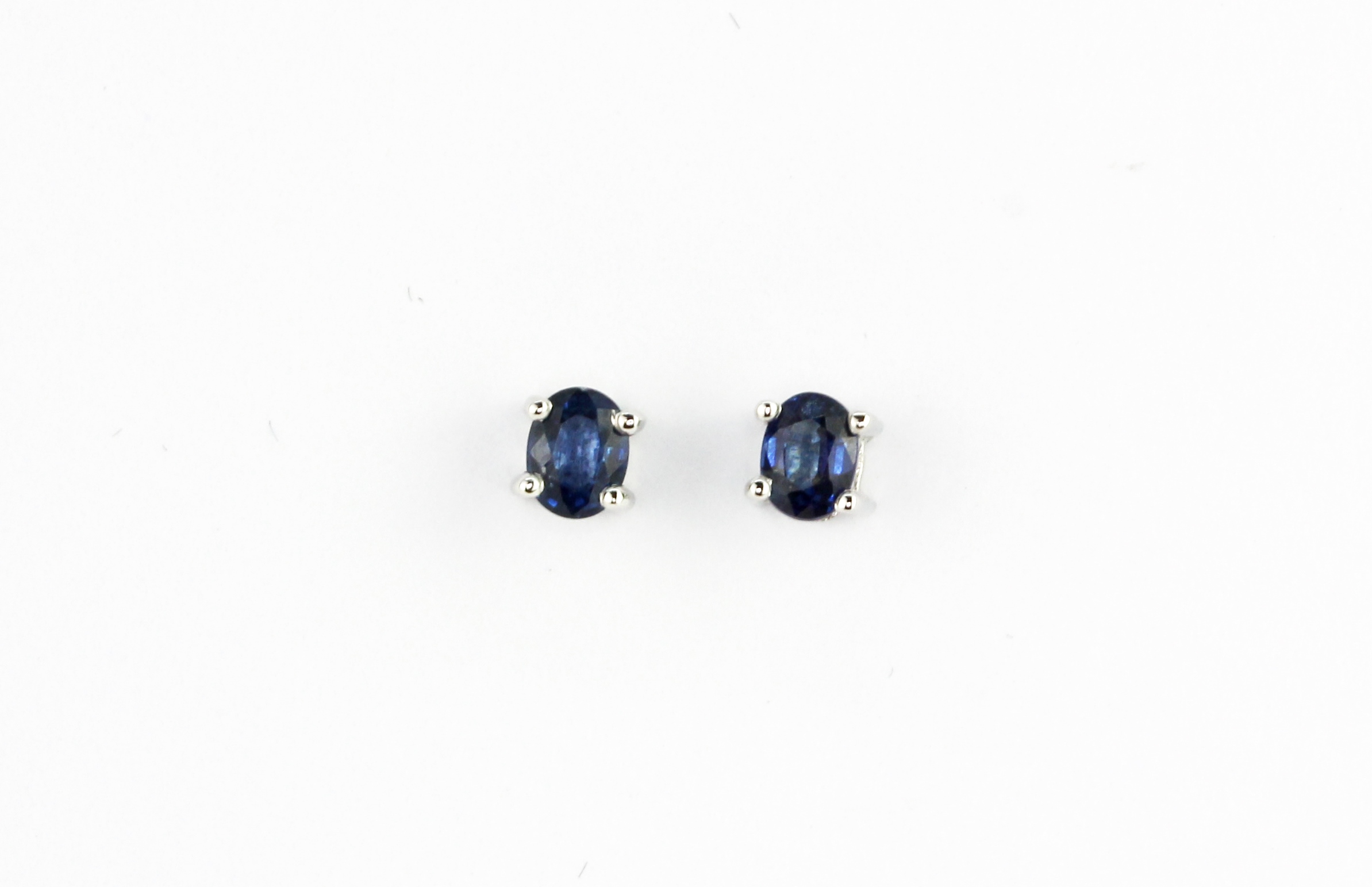 A pair of 14ct white gold stud earrings set with oval cut sapphires, L. 0.4cm.