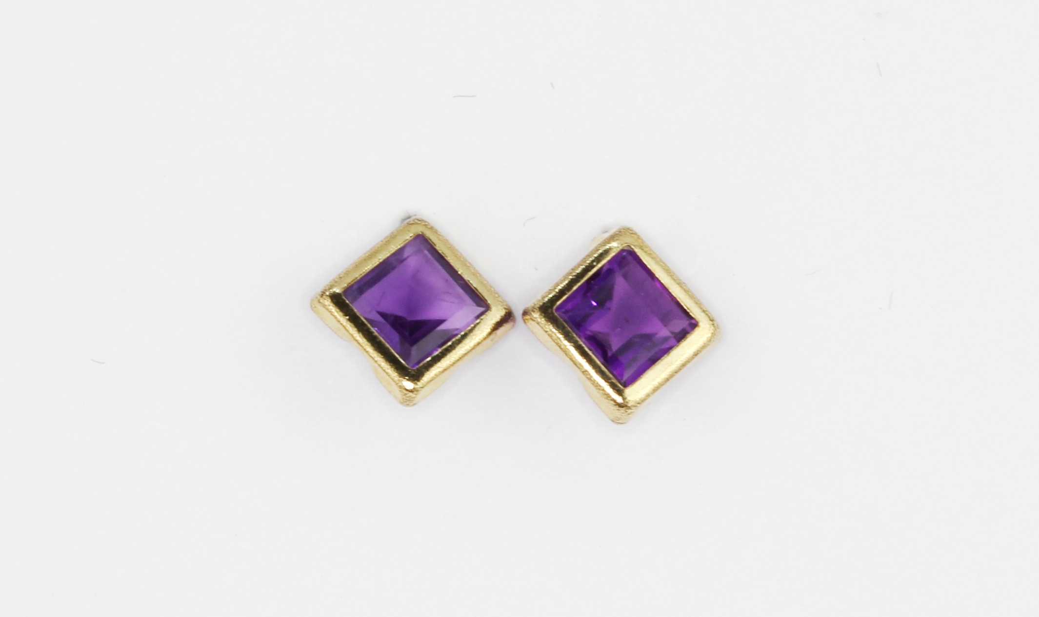 A pair of 9ct yellow gold amethyst set stud earrings, L. 0.6cm.