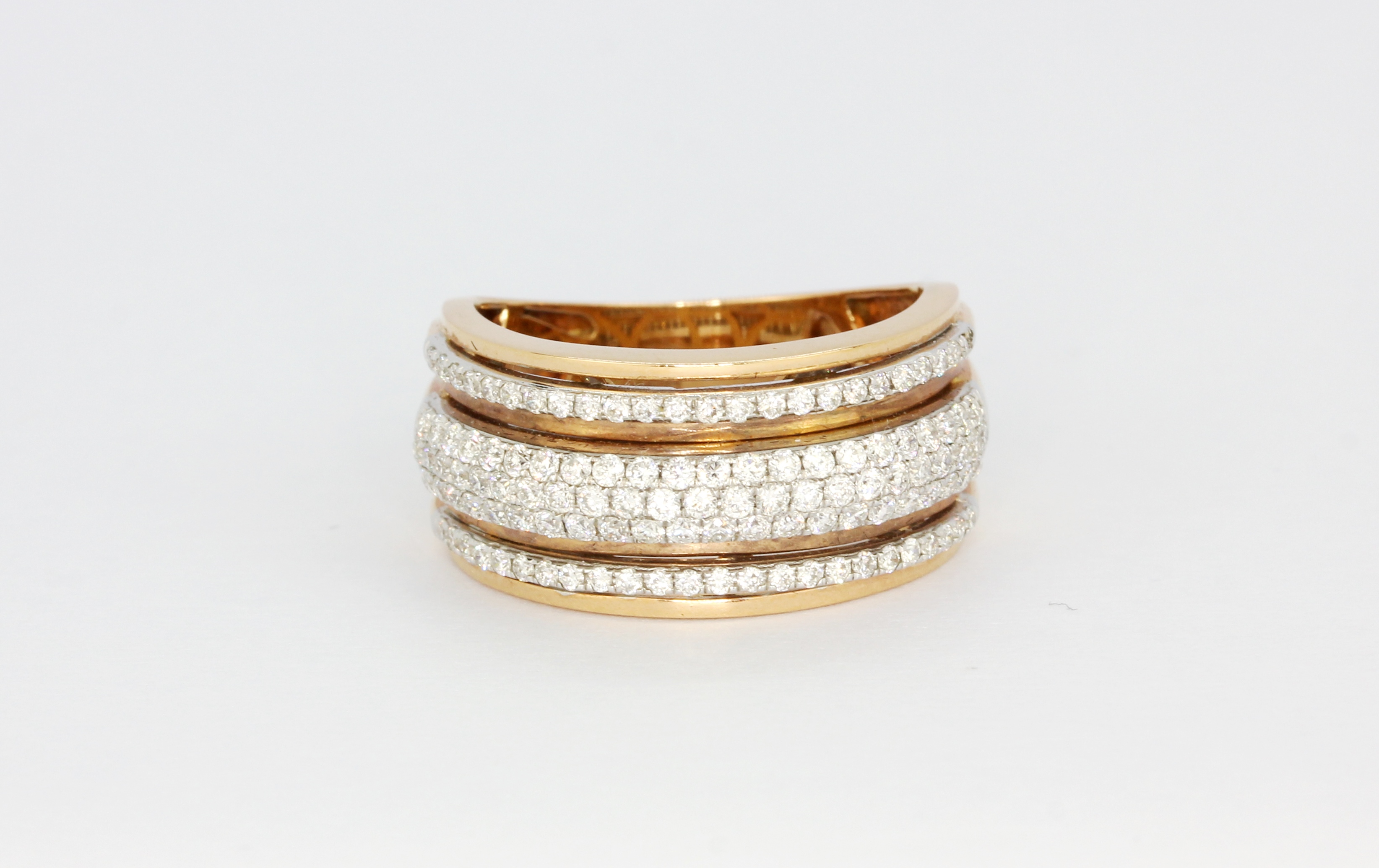 An 18ct rose gold ring set with three rows of brilliant cut diamonds, overall 0.78ct, (M).