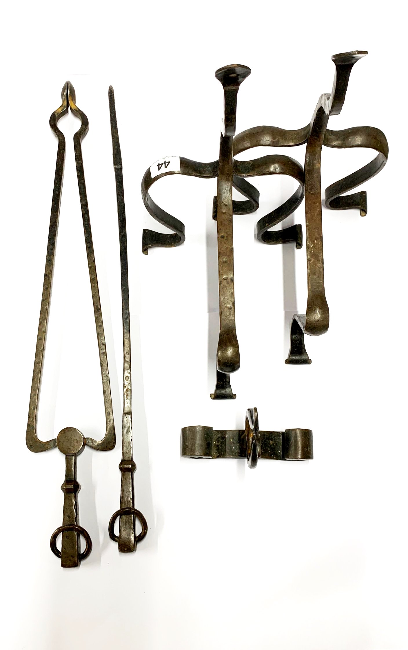 A pair of hammered iron andirons with poker, tongs and poker rest, tongs L. 67cm.