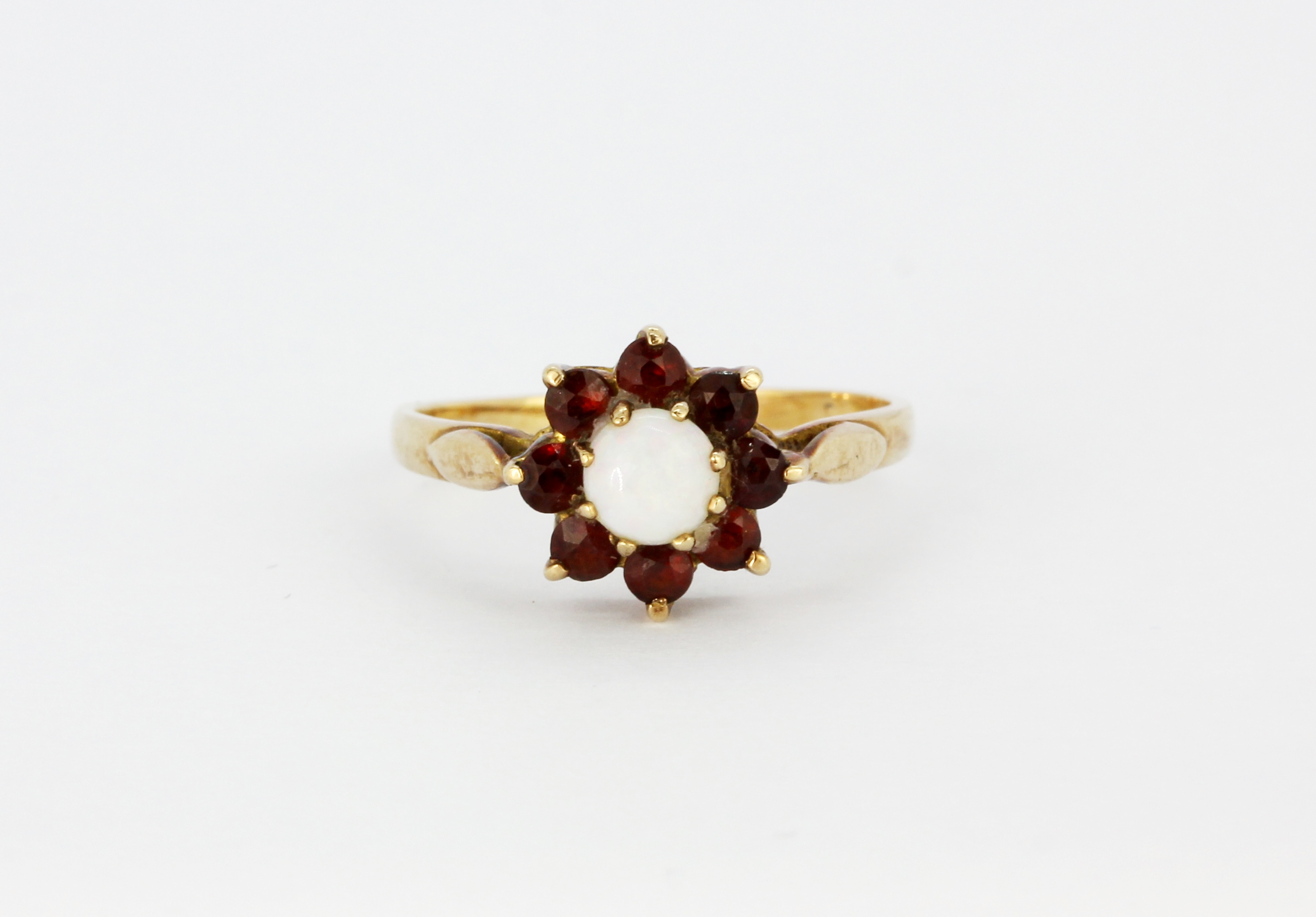 A 9ct yellow gold opal and garnet set cluster ring, (O).