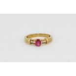 A 9ct yellow gold ring set with an oval cut ruby and diamond set shoulders, (M.5).