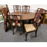 A 1920's carved mahogany extending oval dining table with ball and claw feet with a set of six