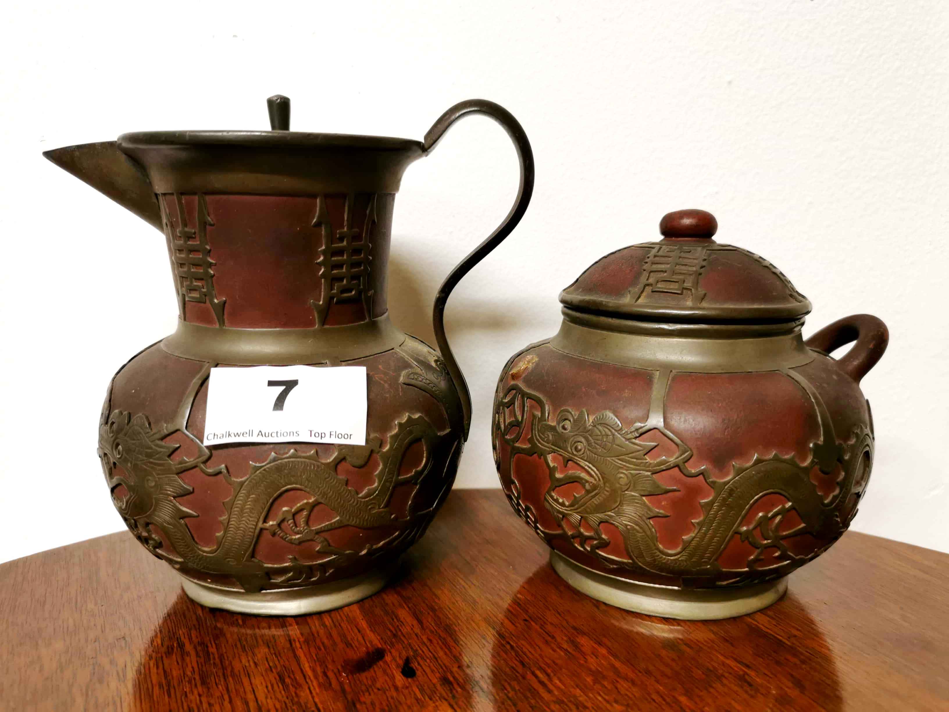 An early 20th C. Chinese pewter overlaid Yixing terracota jug, H. 14cm, together with a matching