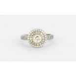 An 18ct white gold halo ring set with a brilliant cut centre diamond surrounded by brilliant cut