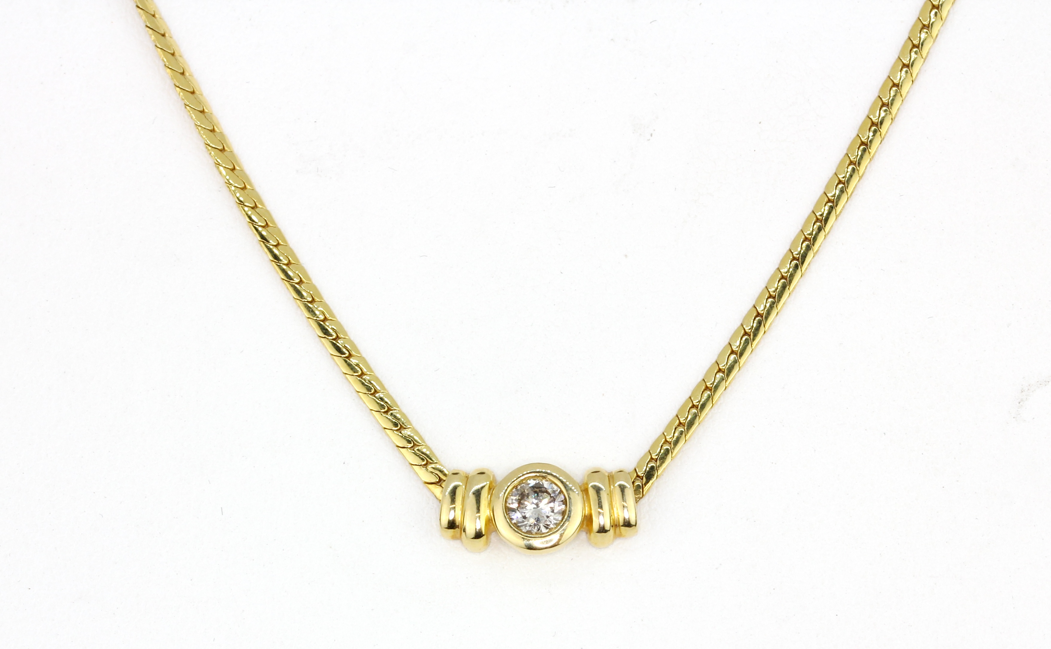 An 18ct yellow gold (stamped 750) necklace set with a brilliant cut diamond, L. 42cm.