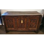 An 17th C. with later carved oak plank top coffer, 138cm x 60cm x 79cm.