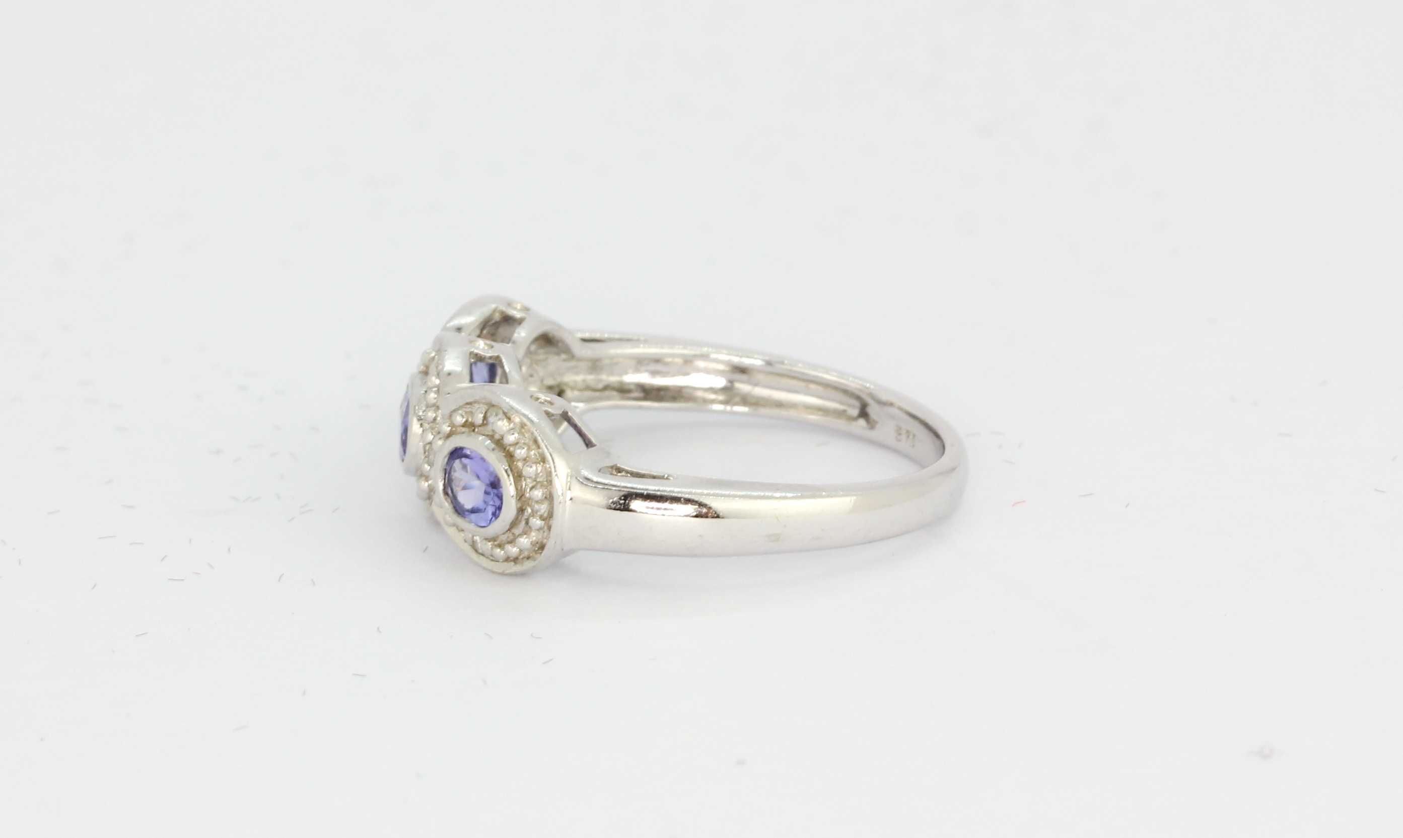 A 9ct white gold tanzanite and diamond set triple cluster ring, (L). - Image 2 of 2