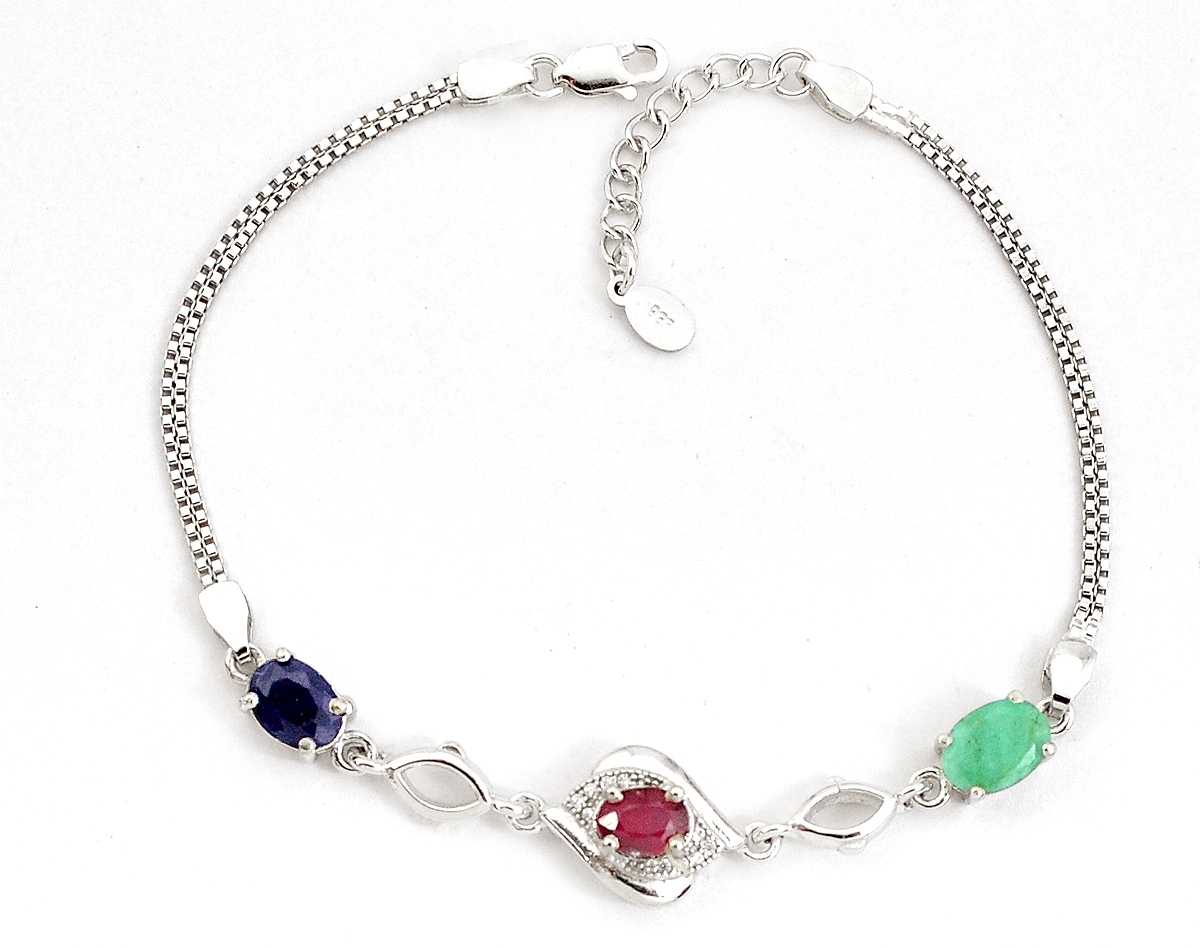 A 925 silver bracelet set with oval cut ruby, sapphire and emerald and white stones, L. 21cm.