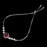 A 925 silver adjustable bracelet set with a cabochon cut ruby and white stones.