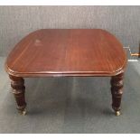 A large 19th Century mahogany wind-out dining table, 135 x 147cm. extending to 248cm with two