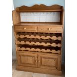 A pine tile inset kitchen cabinet with an in-built wine rack, 100 x 150cm. Condition: some tiles A/