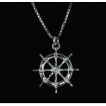 An 18ct white gold diamond set ship's wheel shaped pendant and chain, L. 2.3cm.