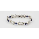 A boxed white metal (tested 18ct gold) bracelet set with cabochon cut sapphires and brilliant cut