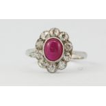 An 18ct white gold cluster ring set with a cabochon cut ruby surrounded by brilliant cut diamonds,